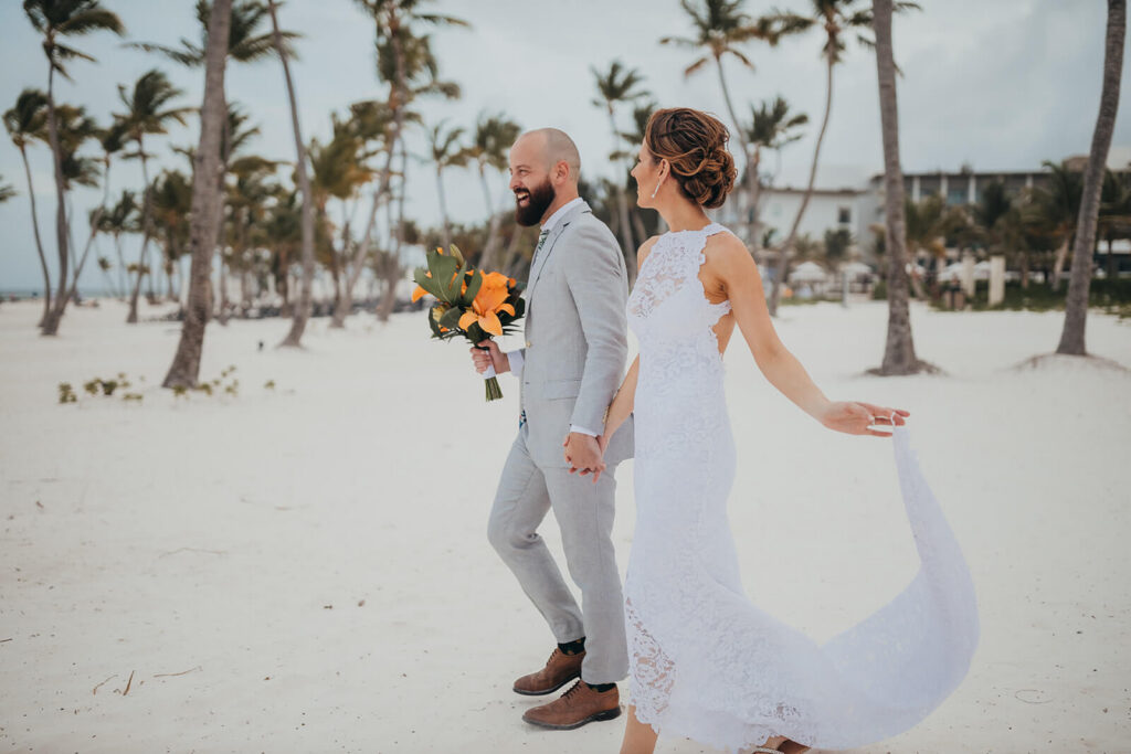 Amy and Drew walking hand in hand on the beach at Hyatt Zilara Cap Cana on their destination wedding day