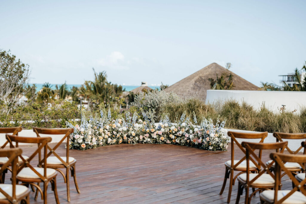 Rooftop ceremony with a low floral installation in powder blue, peach and white blooms at Secrets Playa Blanca